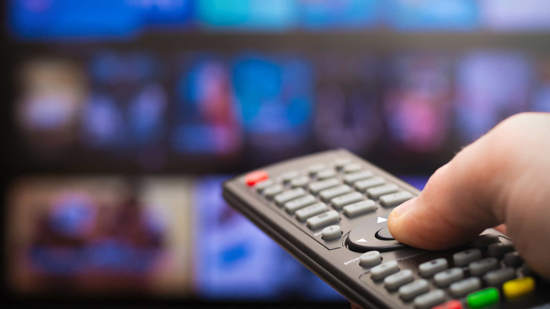 TV remote pointing at a TV with fingers clicking on a button